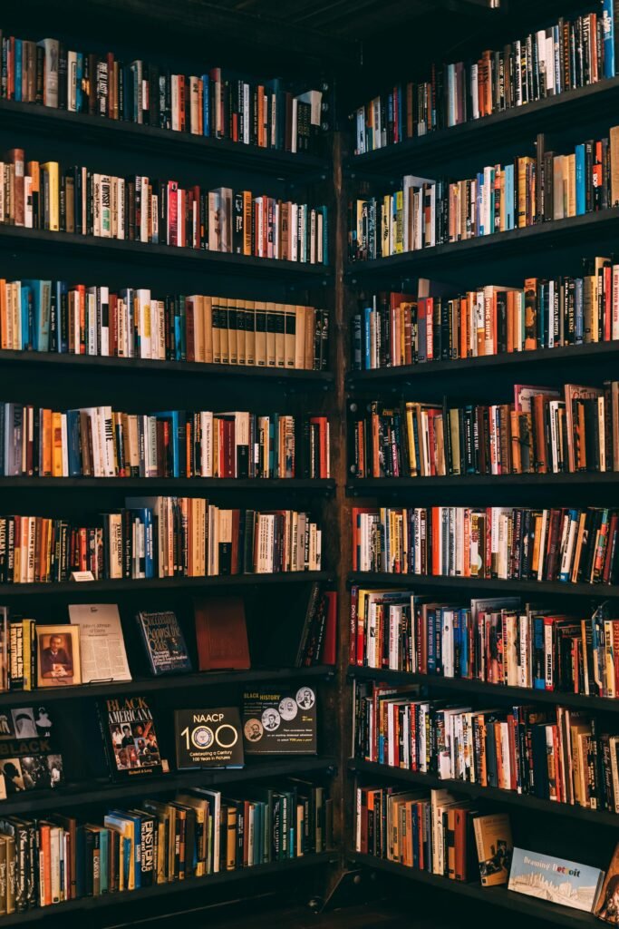 pexels-photo-1907785-1907785 Corner view of a library with dark wooden bookshelves filled with a variety of books.