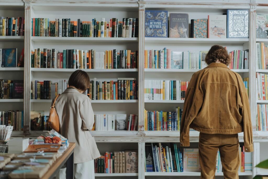 pexels-photo-4861300-4861300 Two adults browsing books in a cozy bookstore, enjoying leisure time and self-education.